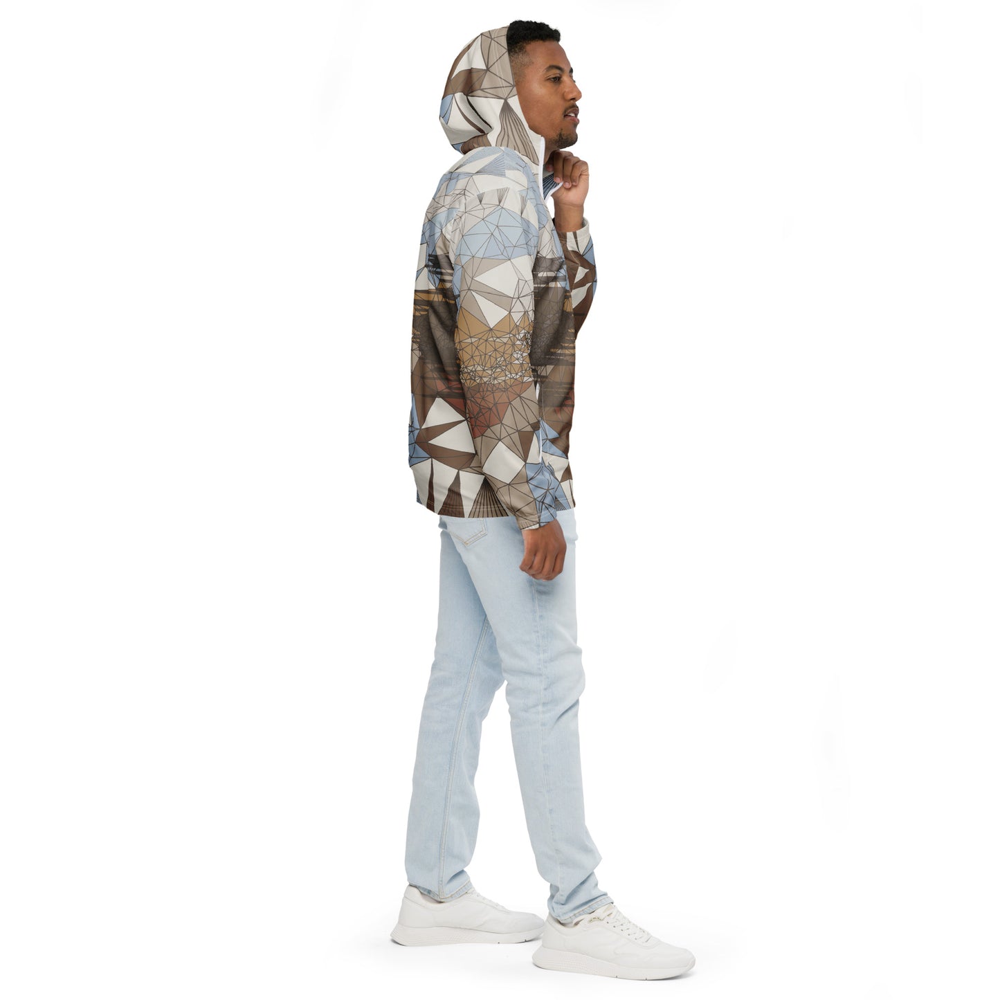 Man wearing a geometric patterned windbreaker and light blue jeans on a white background