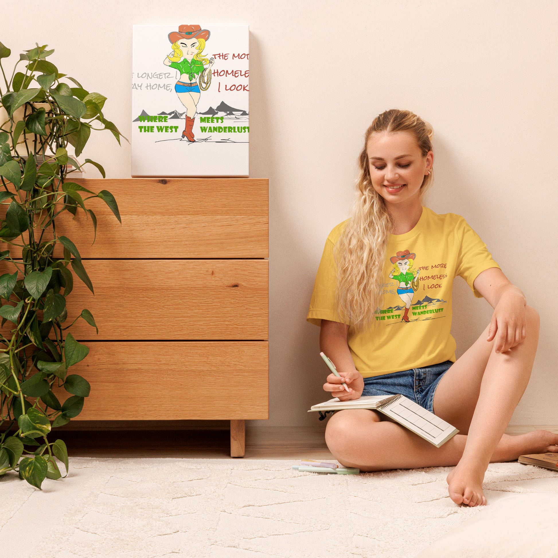Woman sitting on the floor reading a book with a yellow t-shirt featuring a playful cowgirl graphic design and text.